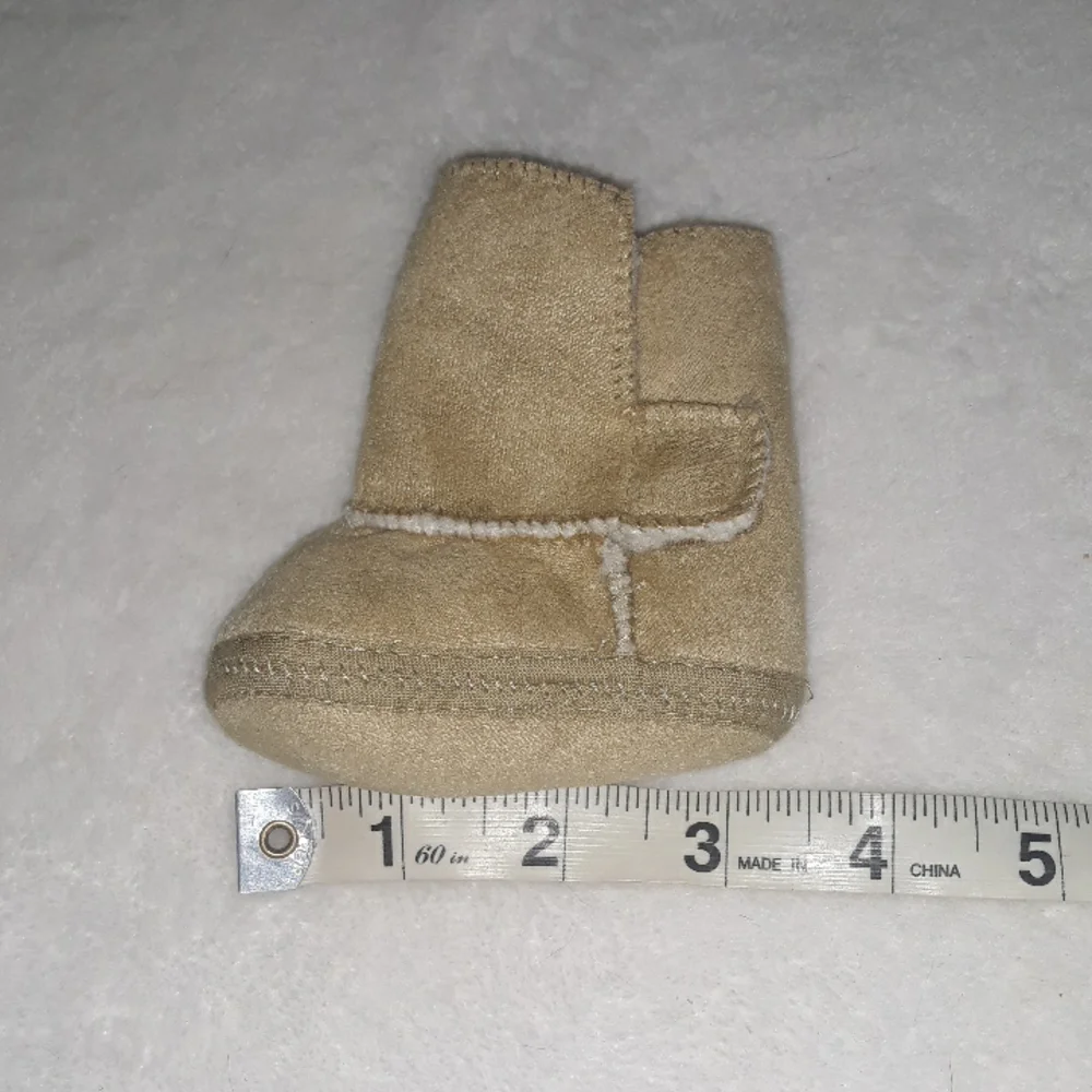 Newborn Tan soft baby boots with warm inner layer.